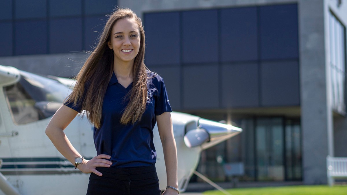student standing in front of a plane