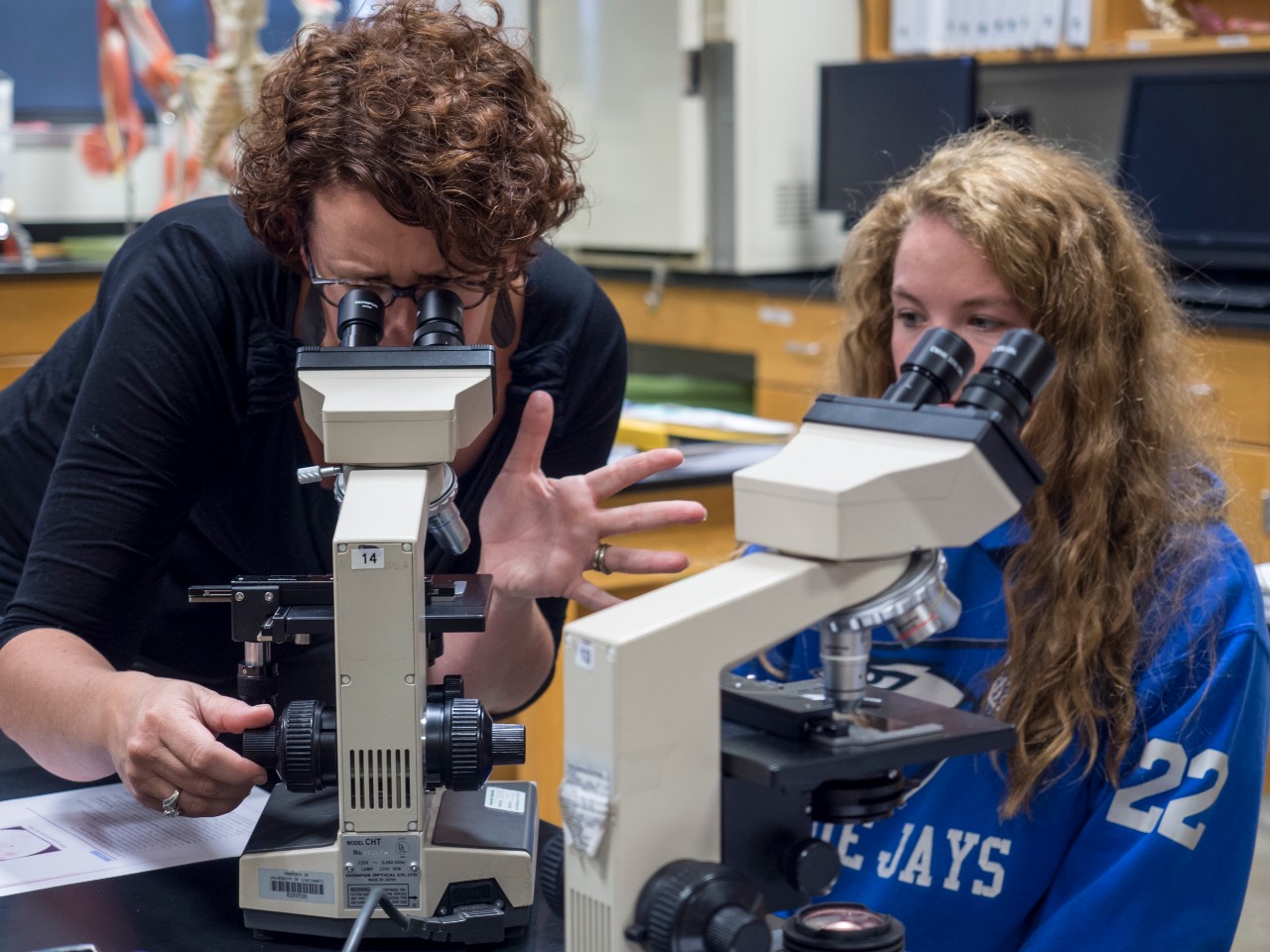 Krista Clark using microscope with student